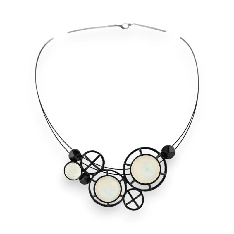Collier géométrique noir et blanc avec cercles et croix, design moderne et épuré