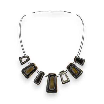 Collier géométrique argenté avec pendentifs noirs et verts, design moderne et élégant