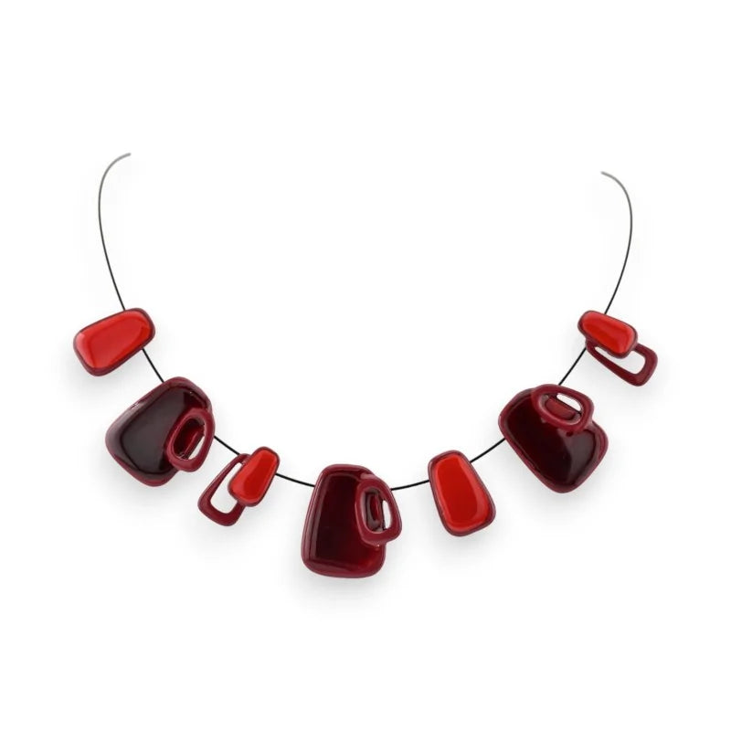 Collier géométrique avec perles rouges et bordeaux de formes variées sur fil argenté