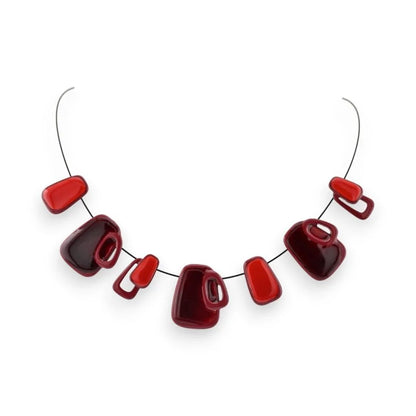 Collier géométrique avec perles rouges et bordeaux de formes variées sur fil argenté