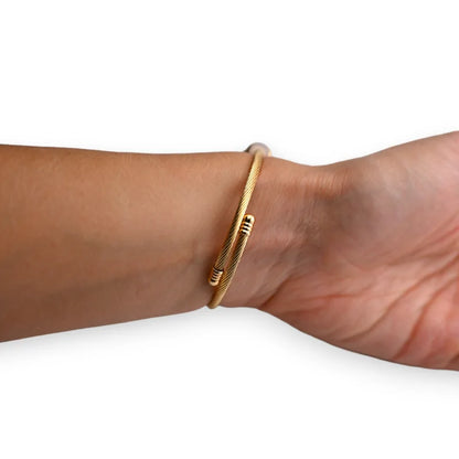 Bracelet jonc doré fin porté au poignet, design minimaliste et élégant